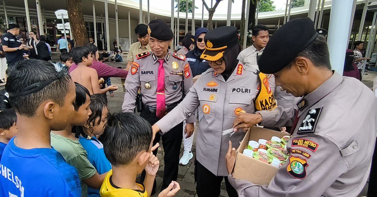 Kapolres Metro Bekasi Kombes Pol Sumarni membagikan susu dan makanan ringan saat meninjau keamanan di lokasi wisata air di Tambun Selatan. (Putra)