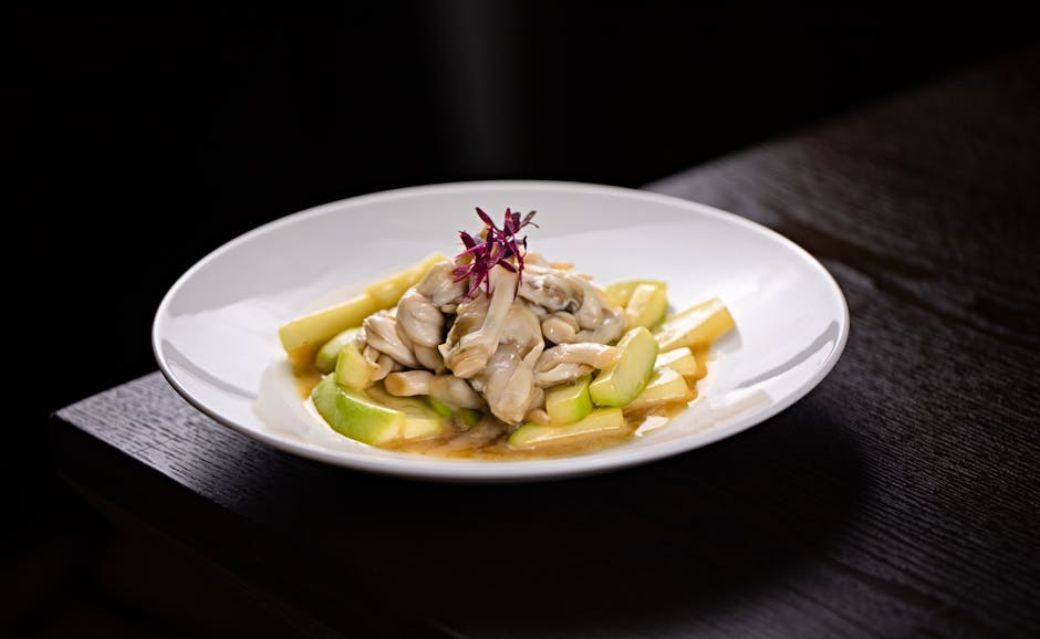 Sepiring tempe goreng dan tempe mentah yang disajikan secara estetis di atas daun pisang tradisional.